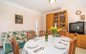 a dining room with a table and a tv at Stunning apartment in Icici with 1 Bedrooms and WiFi in Ičići