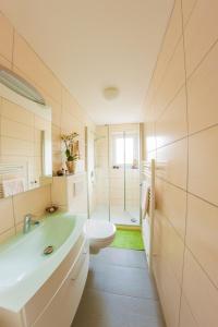 a white bathroom with a sink and a toilet at Wilbergerhof RoyalThai in Horn-Bad Meinberg