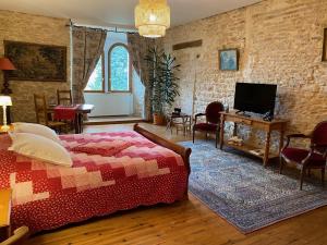 Bed and Breakfast Le Château de Morey في Morey: غرفة نوم بسرير وتلفزيون في غرفة