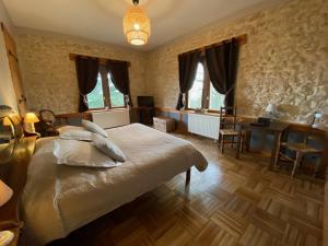 Bed and Breakfast Le Château de Morey في Morey: غرفة نوم بسرير ومكتب ونوافذ