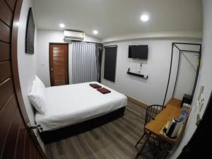Habitación pequeña con cama y mesa en The Ghee House, en Chiang Mai