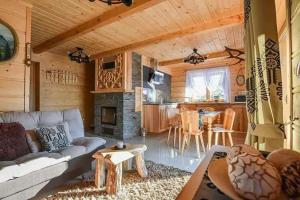 un soggiorno con un divano, un tavolo e una cucina di Tatrzanskie domki a Poronin