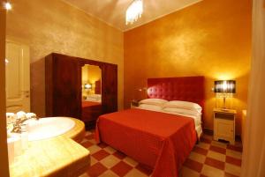 ein Schlafzimmer mit einem Bett und einem Waschbecken sowie ein Badezimmer in der Unterkunft Malö Suites in SantʼEgidio alla Vibrata