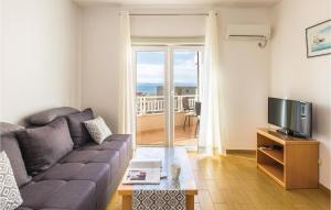 uma sala de estar com um sofá e uma televisão em Cozy Apartment In Makarska With Kitchen em Makarska