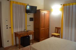 een slaapkamer met een bed, een houten kast en een bureau bij B&B Al Tramonto Portopalo in Portopalo
