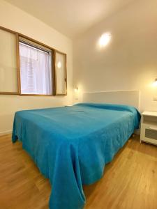 a large blue bed in a room with a window at Camping Calabrisella in Borgia