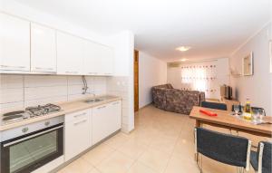 eine Küche mit weißen Schränken, einem Tisch und einer Couch in der Unterkunft Awesome Home In Okrug Gornji With Kitchen in Trogir