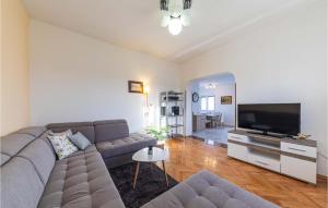 a living room with a couch and a flat screen tv at 3 Bedroom Beautiful Apartment In Kastel Kambelovac in Kaštela