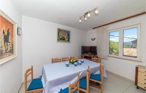 ein Esszimmer mit einem Tisch und einem TV in der Unterkunft Nice Home In Drvenik Mali With Kitchen in Velike Kuknjare