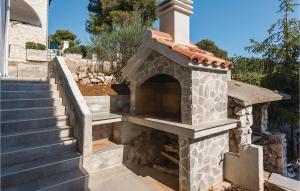 an outdoor fireplace with a staircase in a house at Two-Bedroom Apartment In Brodarica in Brodarica