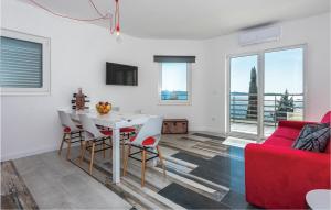 a living room with a table and a red couch at Two-Bedroom Apartment In Brodarica in Brodarica +17 photos