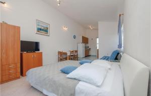 a bedroom with a white bed with blue pillows at Cozy Apartment In Razanj With House Sea View in Ražanj