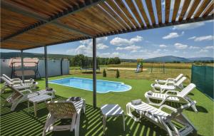 eine Gruppe von Stühlen und einen Pool mit Spielplatz in der Unterkunft Stunning Home In Trilj With House A Panoramic View in Trilj