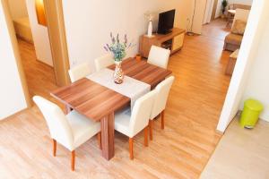 a wooden table with white chairs and a dining room at Apartment Anna Maria in Promajna