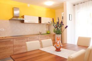 a kitchen with a table with a vase of flowers on it at Apartment Anna Maria in Promajna