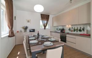 a kitchen with a table with chairs and a dining room at Nice Home In Postira With Wifi in Postira