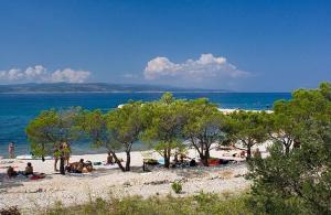 a group of people on a beach near the water at Apartment Anna Maria in Promajna