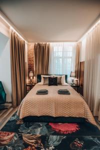 a bedroom with a large bed with two lamps on it at Bahnhofs hotel in Alūksne