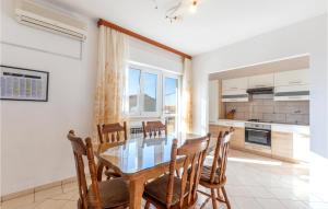 una cucina e una sala da pranzo con tavolo e sedie in vetro di 3 Bedroom Cozy Apartment In Kastel Luksic a Kaštela (Castelli)