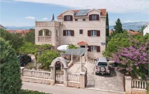 een auto geparkeerd voor een huis met een hek bij Three-Bedroom Apartment In Supetar in Supetar