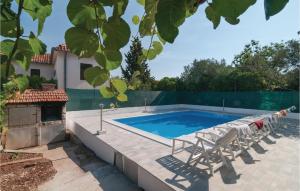 een zwembad met twee stoelen en een tafel bij Three-Bedroom Apartment In Supetar in Supetar