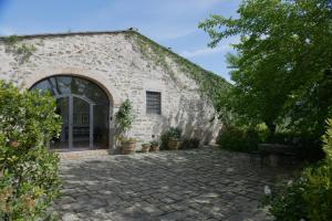 um edifício de pedra com uma porta e um pátio em Fattoria il Leccio - Elegant Suite on Florence Hills em Fiesole