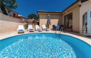 a swimming pool with chairs and a house at Beautiful Home In Marcana With Wifi in Marčana