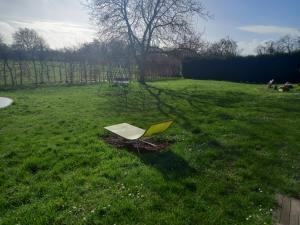 une chaise assise dans l'herbe dans un champ dans l'établissement Bungalow la Bohémienne, à Oissel