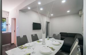a dining room with a table with plates and glasses at Beach Front Home In Omis in Omiš