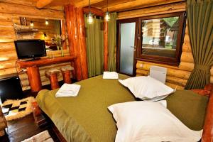 a bedroom with two beds in a log cabin at Complex Stejarul in Tuluceşti