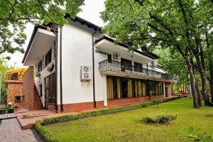 a white building with a balcony and a yard at Complex Stejarul in Tuluceşti