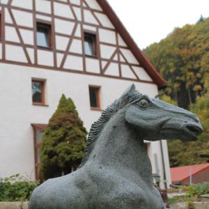 uma estátua de um cavalo em frente a um edifício em VIA MALA Apartment em Kirchensittenbach