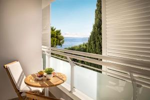 a balcony with a table and a view of the ocean at Valamar Sanfior Hotel & Casa in Rabac +34 photos