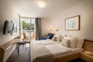 a hotel room with a bed and a window at Valamar Sanfior Hotel & Casa in Rabac