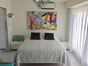 una camera da letto con un letto e un quadro sul muro di Le Ponteil plage a Antibes