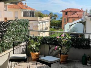 un balcone con 2 sedie e piante in vaso di Le Ponteil plage a Antibes