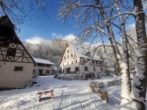 a snow covered village with a building and a bench at VIA MALA Apartment in Kirchensittenbach