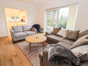 ein Wohnzimmer mit einem Sofa und einem Tisch in der Unterkunft Hillcrest in Wrexham