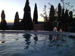 a swimming pool with a lit candle and trees at Locanda nel Cassero in Civitella Marittima
