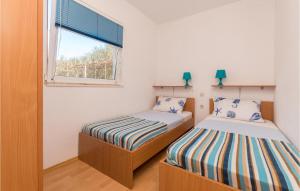 2 camas en una habitación pequeña con ventana en Nice Apartment In Biograd Na Moru With Kitchen, en Biograd na Moru