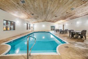 una piscina en una casa con mesa y sillas en Americas Best Value Inn Marquette, en Marquette