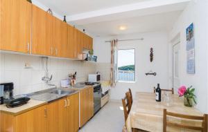 una cocina con armarios de madera y una mesa con comedor. en Stunning Apartment In Gruda With Wifi, en Gruda