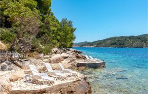 een groep stoelen aan de oever van een meer bij Holiday Home Sokolic Bb Cr in Vela Luka