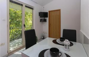 a kitchen with a table and chairs and a window at Nice Apartment In Arbanija With 1 Bedrooms And Wifi in Trogir