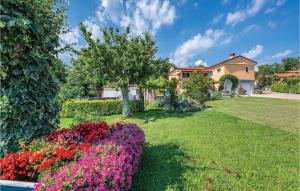 a garden with flowers and a house in the background at Cozy Apartment In Pican With Kitchen in Pićan