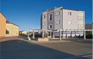 un grand bâtiment blanc à côté d'une rue dans l'établissement Apartment Vodnjan Peroj Ii, à Vodnjan