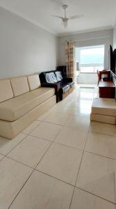uma sala de estar com um sofá e uma mesa em Apartamento Praia Grande Vila Caiçara na Praia Grande