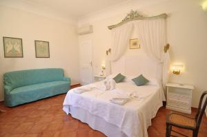 - une chambre avec un lit et un canapé bleu dans l'établissement La Zinefra Amalfi Dreams, à Minori