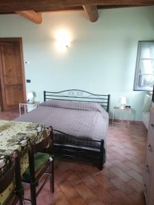 um quarto com uma cama, uma mesa e uma cadeira em Casale Poggio Meone em Santa Luce