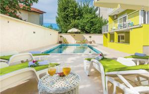 eine Terrasse mit einem Tisch und Stühlen sowie einem Pool in der Unterkunft 5 Bedroom Cozy Home In Pula in Pula